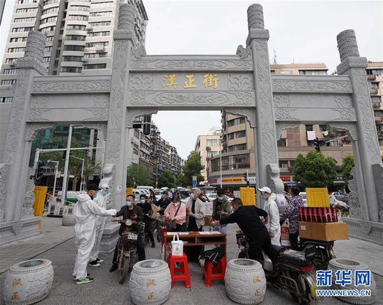  4月16日，進(jìn)出武漢漢正街步行街的人員在掃描健康碼。新華社記者 王毓國 攝